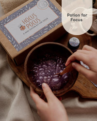 Behind The Trees - Hocus Pocus potion kit with a wooden bowl containing a purple potion, labeled 'Potion for Focus'. - The Little Potion Co - Mini Potion Kit - Hocus Pocus 