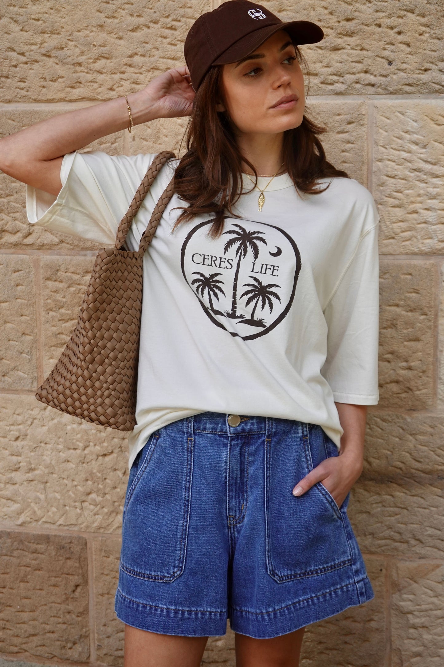 Behind The Trees - Woman in denim outfit walking on a street with a tattoo parlor in the background -Ceres Life - Weekender Short - Fresh Indigo