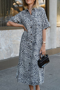 Behind The Trees - Woman wearing a leopard print dress holding a black clutch against a building background - Ceres Life - Ava Short Sleeve Midi Dress - Leopard Linen Blend