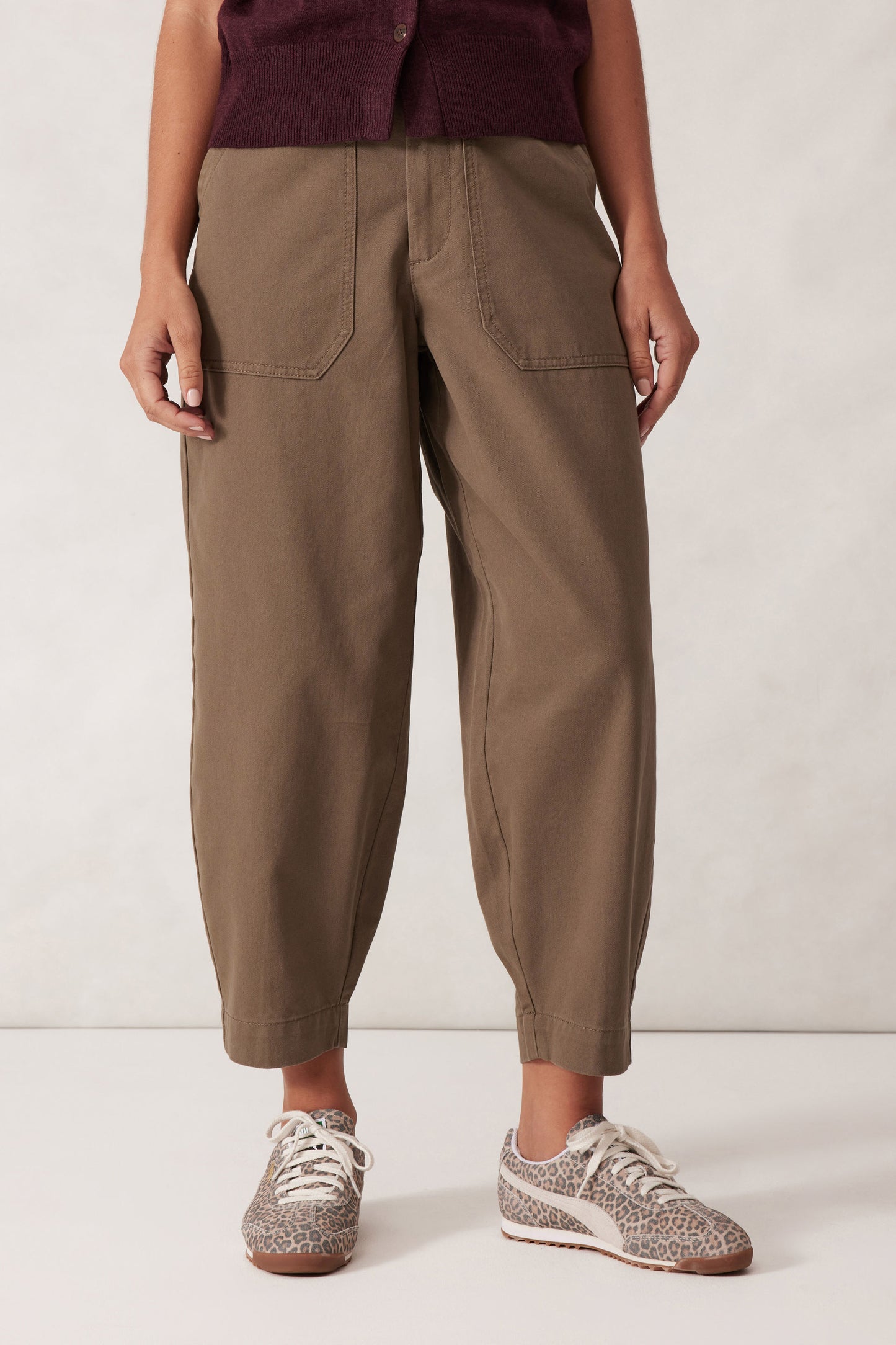 Behind The Trees - Woman wearing a sleeveless maroon top and beige pants against a white background - Ceres Life - Weekender Pant - Moss