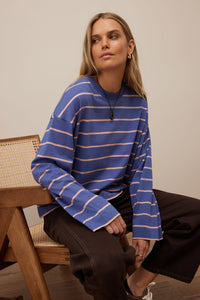 Behind The Trees - Woman wearing a blue and white striped sweater sitting on a chair. - Ceres Life - Beau Long Sleeve Slouchy Tee - Washed Navy/Pink Clay
