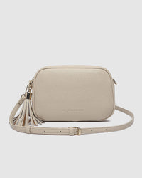 Behind The Trees - Beige crossbody bag with tassel on a light gray background - Louenhide - Jacinta Gia Crossbody Bag - Biscotti
