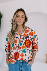 Behind The Trees - Woman wearing a colorful floral blouse with a white background - Joop & Gypsy - Emilie Flower Top