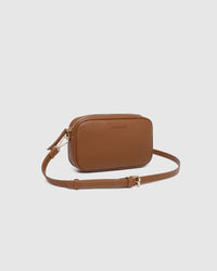 Behind The Trees - Brown leather crossbody bag on a light gray background - Louenhide - Bianca Crossbody Bag - Tan