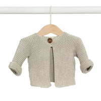 Behind The Trees - Knitted baby cardigan with a button on a wooden hanger against a white background - DLUX - Baby Elf Knitted Cardigan - Shell