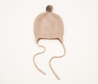 Behind The Trees - Beige knit baby hat with a pom-pom on a white background - DLUX - Huggie Baby Bonnet - Garter Knit with Pompom - Rice