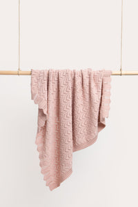 Behind The Trees - Pink textured blanket draped over a wooden rod against a white background - DLUX - Mica Chevron Pointelle Knit Baby Blanket - Pink