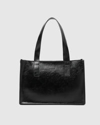 Behind The Trees- Black leather tote bag on a light gray background - Louenhide - Riley Tote Bag - Black Patent