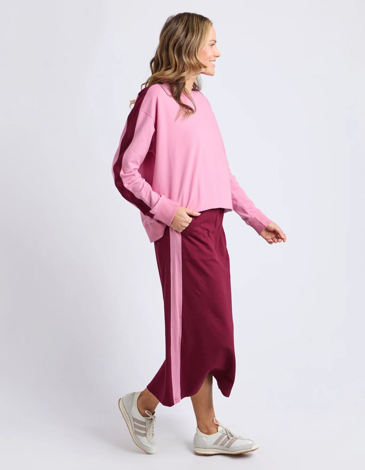 Behind The Trees - Person wearing a pink top and maroon skirt on a white background - Elm - Sloane Fleece Skirt - Plum/Quarts Pink Trim