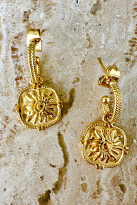 Behind The Trees - Gold earrings with sun design on a textured beige surface - Mosk.Melbourne - Sun and Moon Earrings