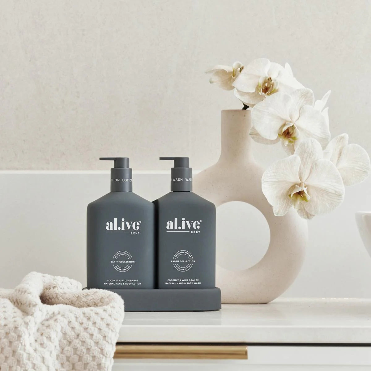 Behind The Trees - Two bottles of al.ive body products with a box in the background on a white background - al.ive - Wash & Lotion Duo - Coconut & Wild Orange