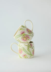 Behind The Trees - Two floral ceramic mugs stacked on a light gray background - Angus & Celeste Buttermilk Mugs - Pink Eucalyptus