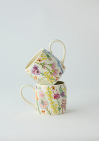 Behind The Trees - Two floral-patterned mugs stacked on a light gray background - Angus & Celeste Buttermilk Mugs - Australian Bush Blooms