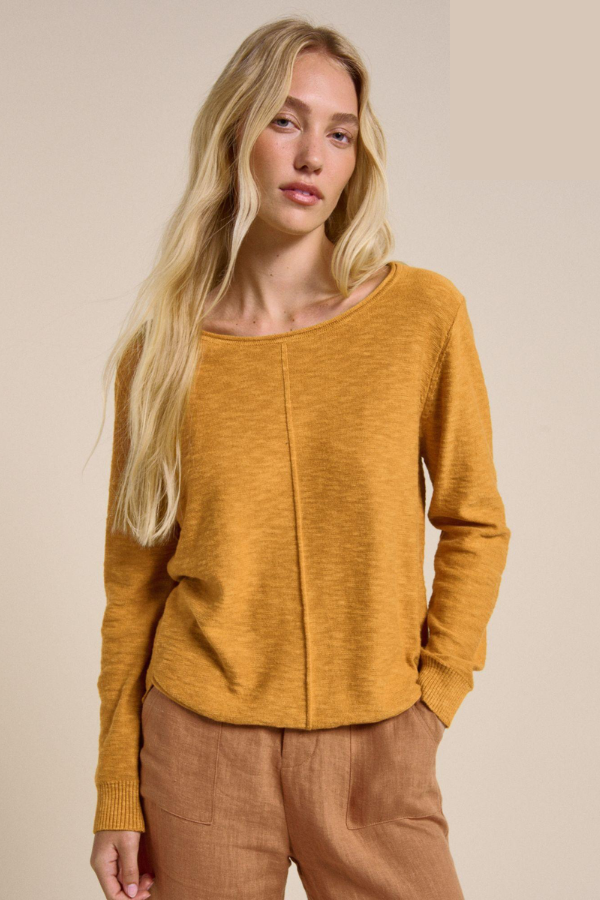 Behind The Trees - Woman wearing a mustard yellow sweater against a beige background - Little Lies - Sacha Top - Mustard