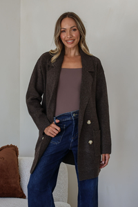 Behind The Trees - Woman wearing a brown coat and blue jeans standing against a neutral background - Miss Marlow - 4 Button Pocket Coatigan - Chocolate