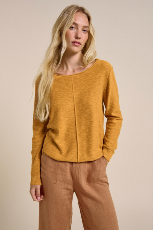 Behind The Trees - Woman wearing a mustard yellow sweater against a beige background - Little Lies - Sacha Top - Mustard