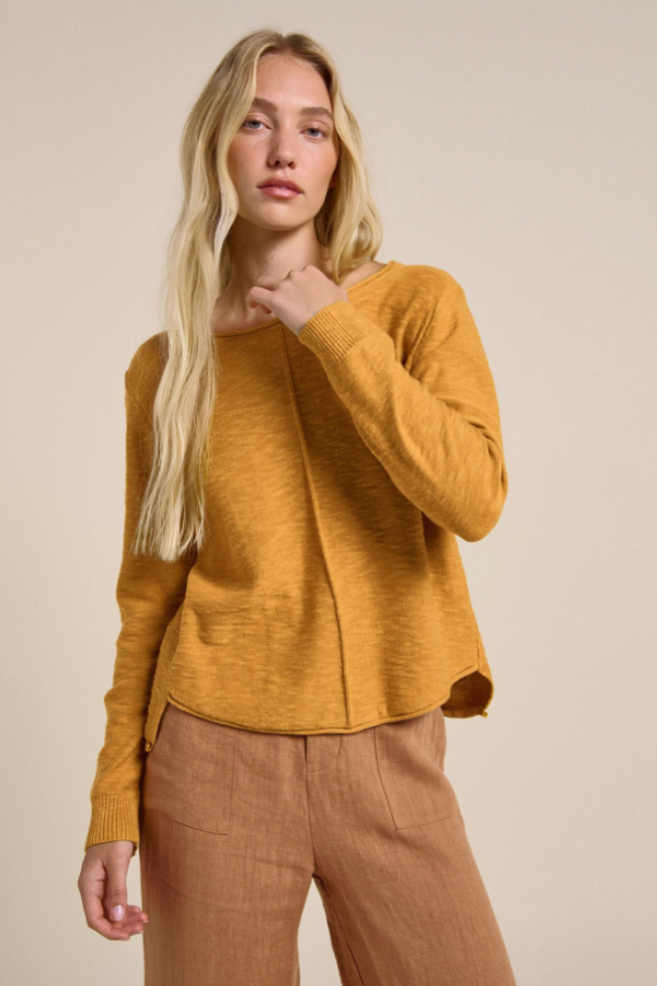 Behind The Trees - Woman wearing a mustard yellow sweater against a beige background - Little Lies - Sacha Top - Mustard