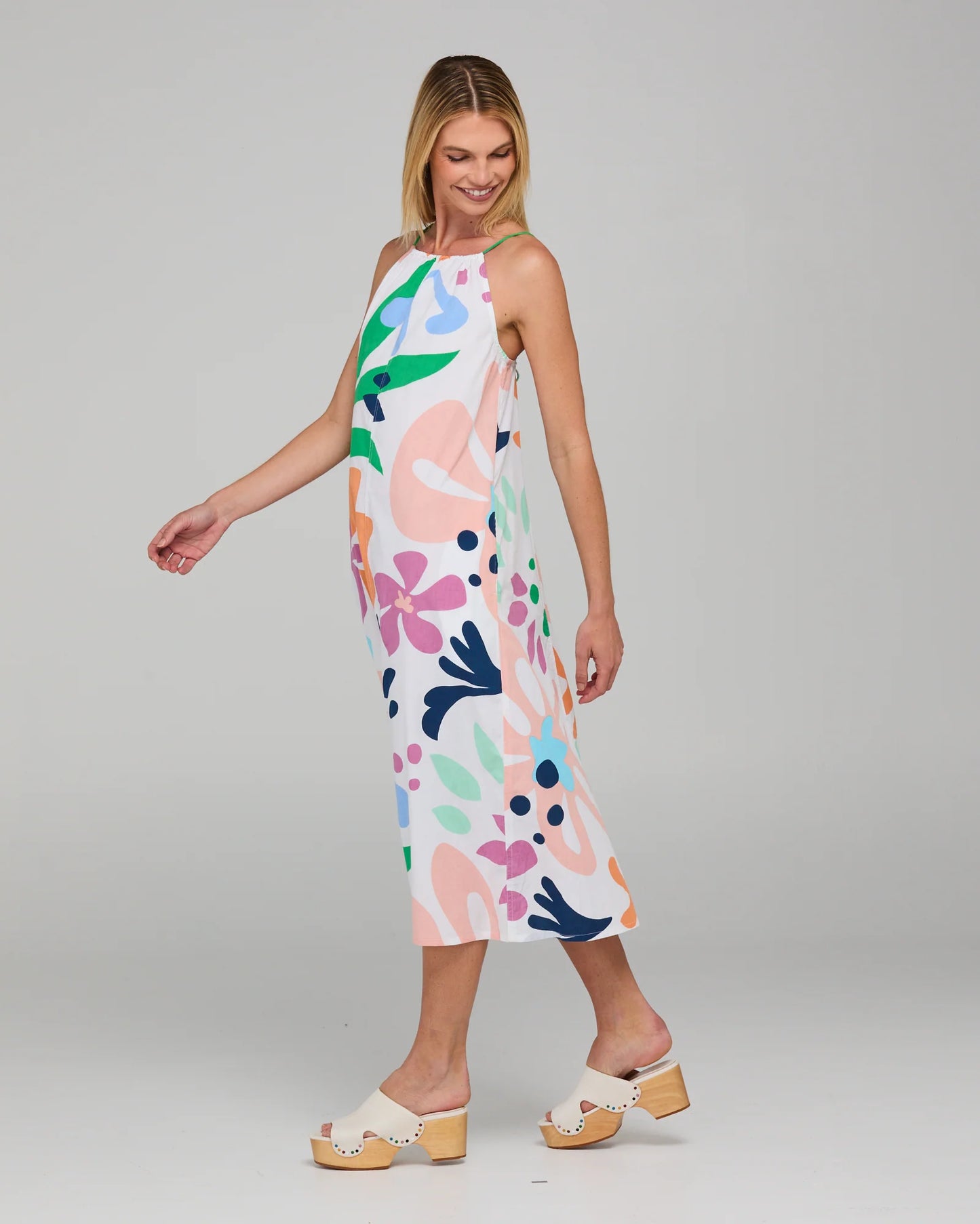 Behind The Trees - Woman wearing a colorful floral dress on a gray background - Boom Shankar - Aria Dress - Sorrento