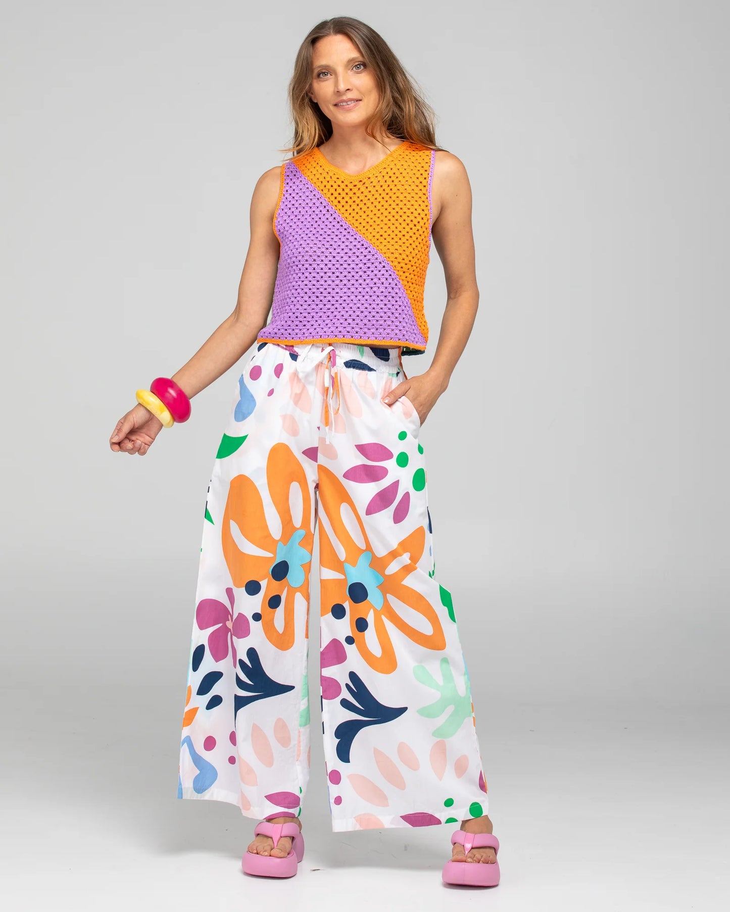 Behind The Trees - Woman wearing a colorful sleeveless top and wide-leg pants with a floral pattern on a gray background - Boom Shankar - Harper Pant - Sorrento