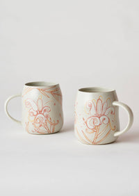 Behind The Trees - Two white ceramic mugs with orange and yellow floral line-art designs, displayed on a light gray background. - Angus & Celeste - Everyday Mugs Two Set - Grevillea