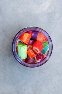 Behind The Trees - Colorful candy pieces spilling out of a glass jar labeled 'SWEET' on a purple background - Sweeta -  Fruit Salad Rock Rock 180g