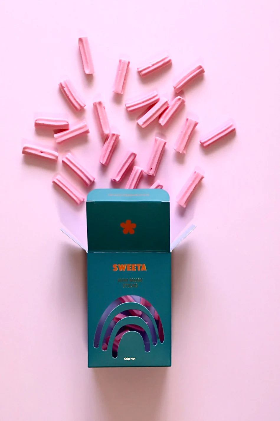 Behind The Trees - Blue box labeled 'SWEETA' with pink items on a pink background - Sweeta - Musk Sticks 100g