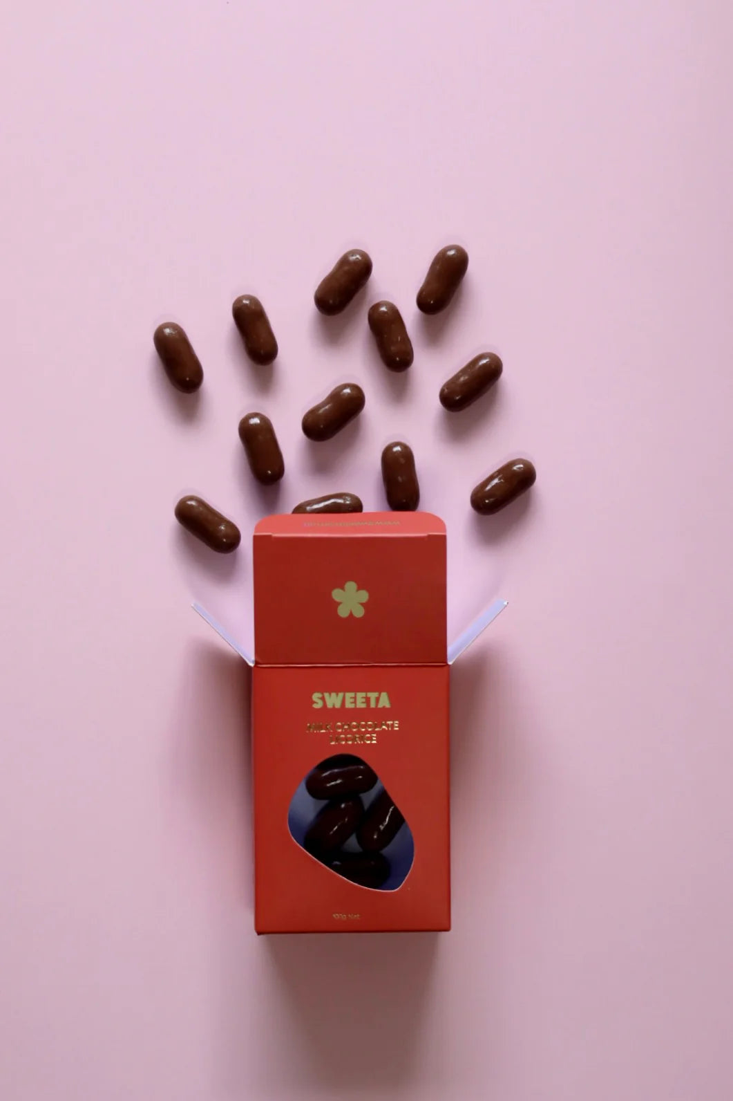 Behind The Trees - Red box labeled 'SWEETA' with chocolate candies on a pink background - Sweeta - Milk Chocolate Licorice 100g