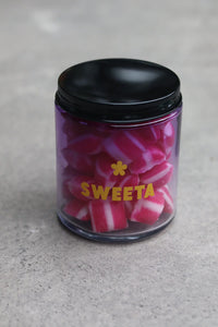 Behind The Trees - Jar of pink and white striped candies with a black lid on a gray surface - Sweeta - Raspberry Humbugs 180g