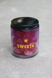Behind The Trees - Jar of pink gummy bears with a black lid on a gray surface, branded 'SWEETA'. - Sweeta -  Raspberry Drops 180g