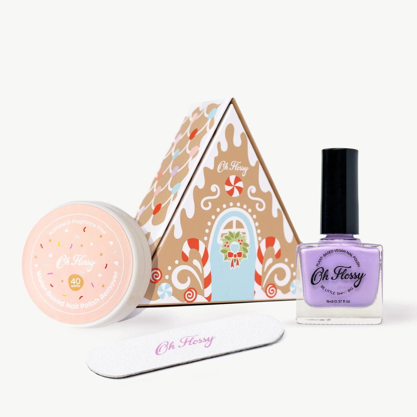 Behind The Trees - Set of Oh Flossy products including a pink jar, a bottle, and a box on a white background- Oh Flossy - Christmas Gingerbread House Mini Mani Set