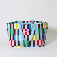 Behind The Trees - Colorful checkered tote bag with blue handles on a light gray background - Project Ten - Oversized Tote - Multi Stripe