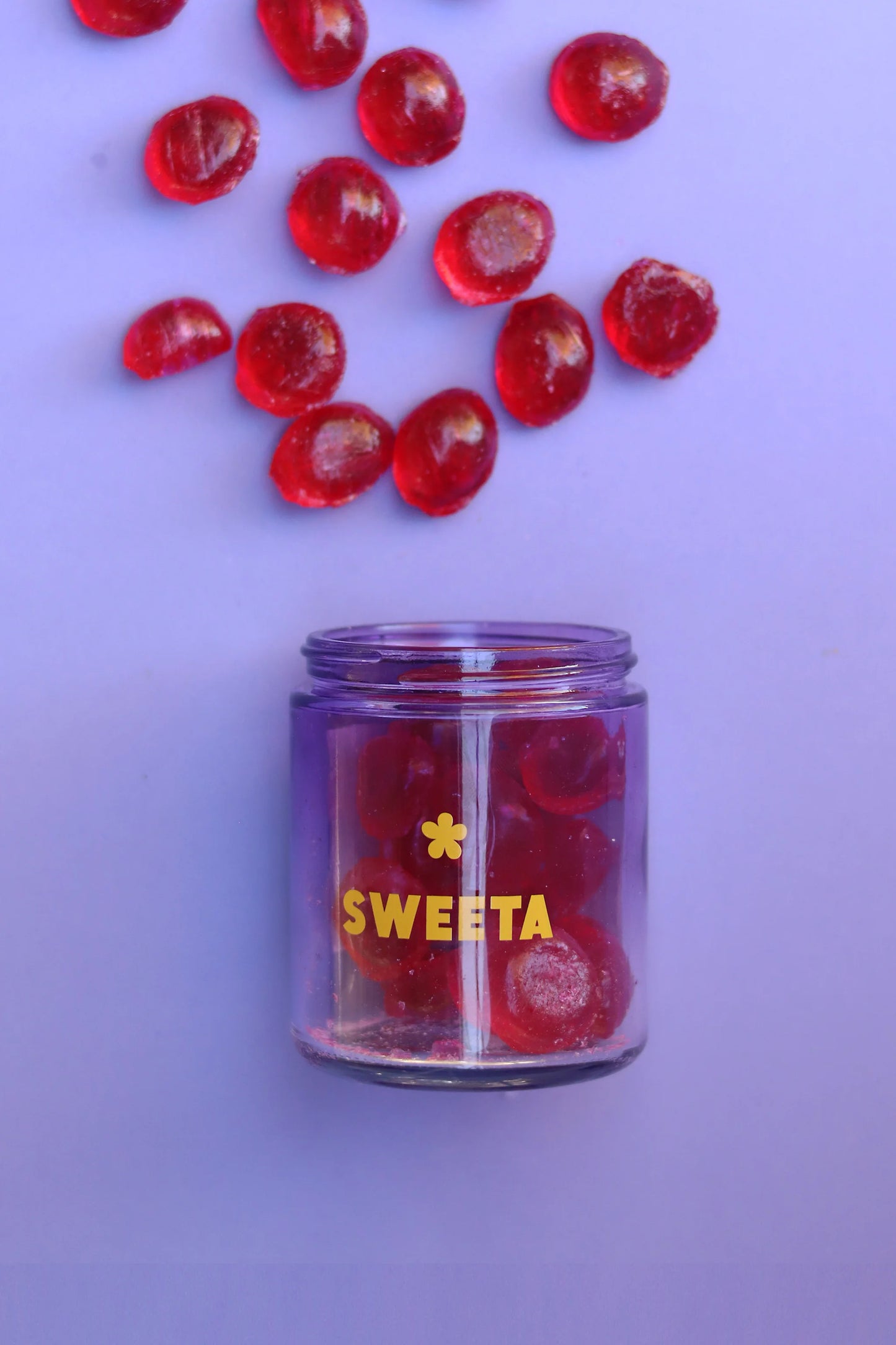 Behind The Trees - Jar of pink gummy bears with a black lid on a gray surface, branded 'SWEETA'. - Sweeta -  Raspberry Drops 180g