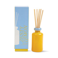 Behind The Trees - Yellow diffuser bottle with wooden sticks and a blue box labeled 'Zesty Lemon' on a white background - Designworks - Stacked 3.2 FL OZ (94ml) Glass Diffuser w/ Light Blue Lid and Yellow Base In a Printed Box - Zesty Lemon