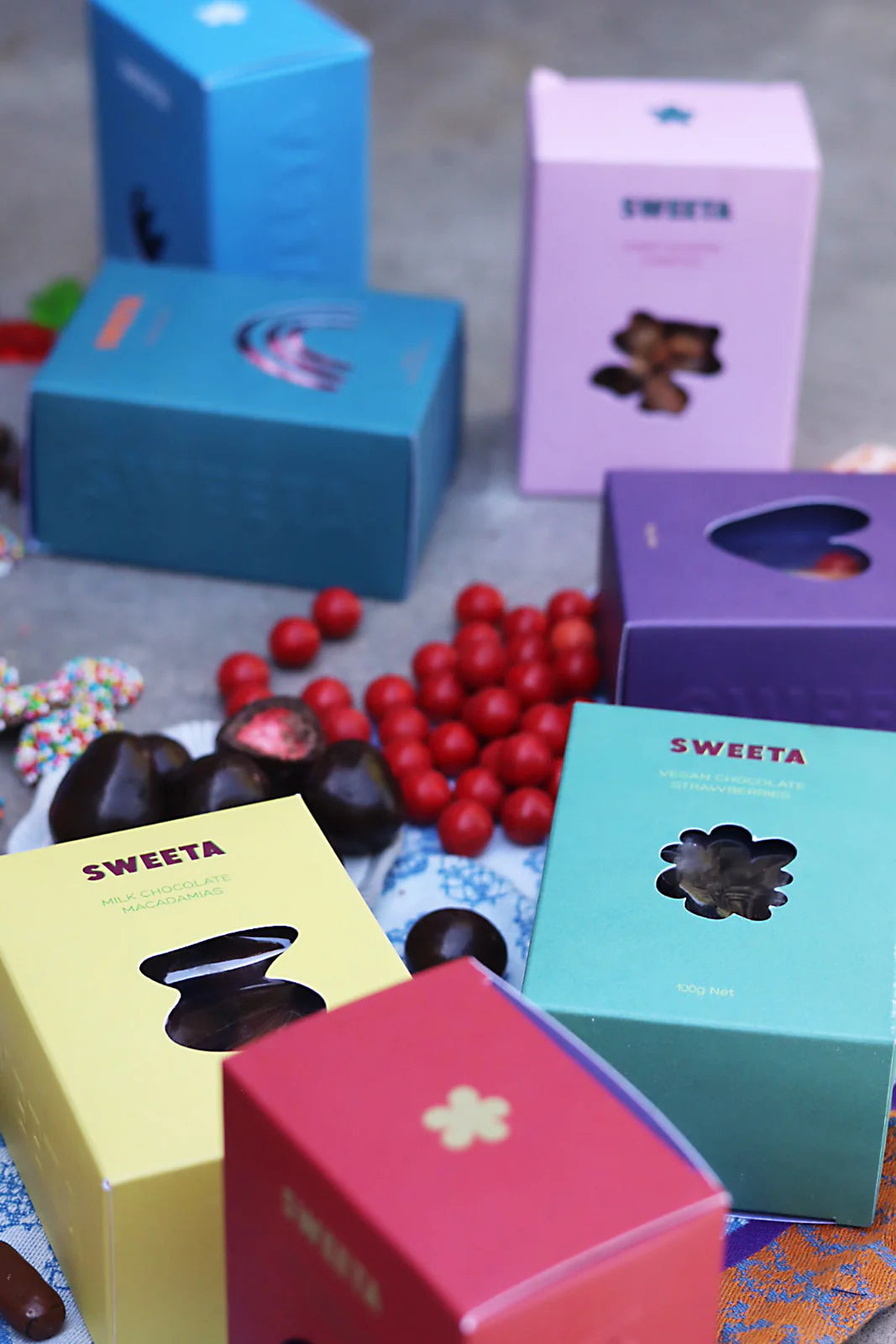 Behind The Trees - Red box labeled 'SWEETA' with chocolate candies on a pink background - Sweeta - Milk Chocolate Licorice 100g