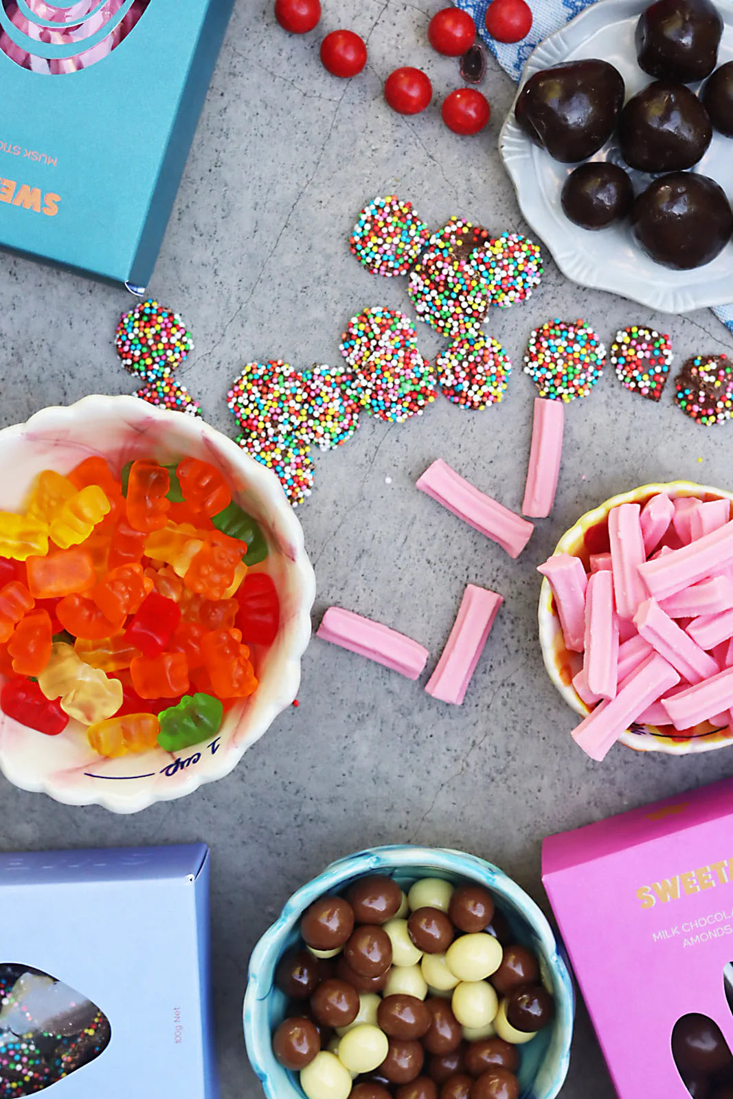 Behind The Trees - Blue box labeled 'SWEETA' with pink items on a pink background - Sweeta - Musk Sticks 100g