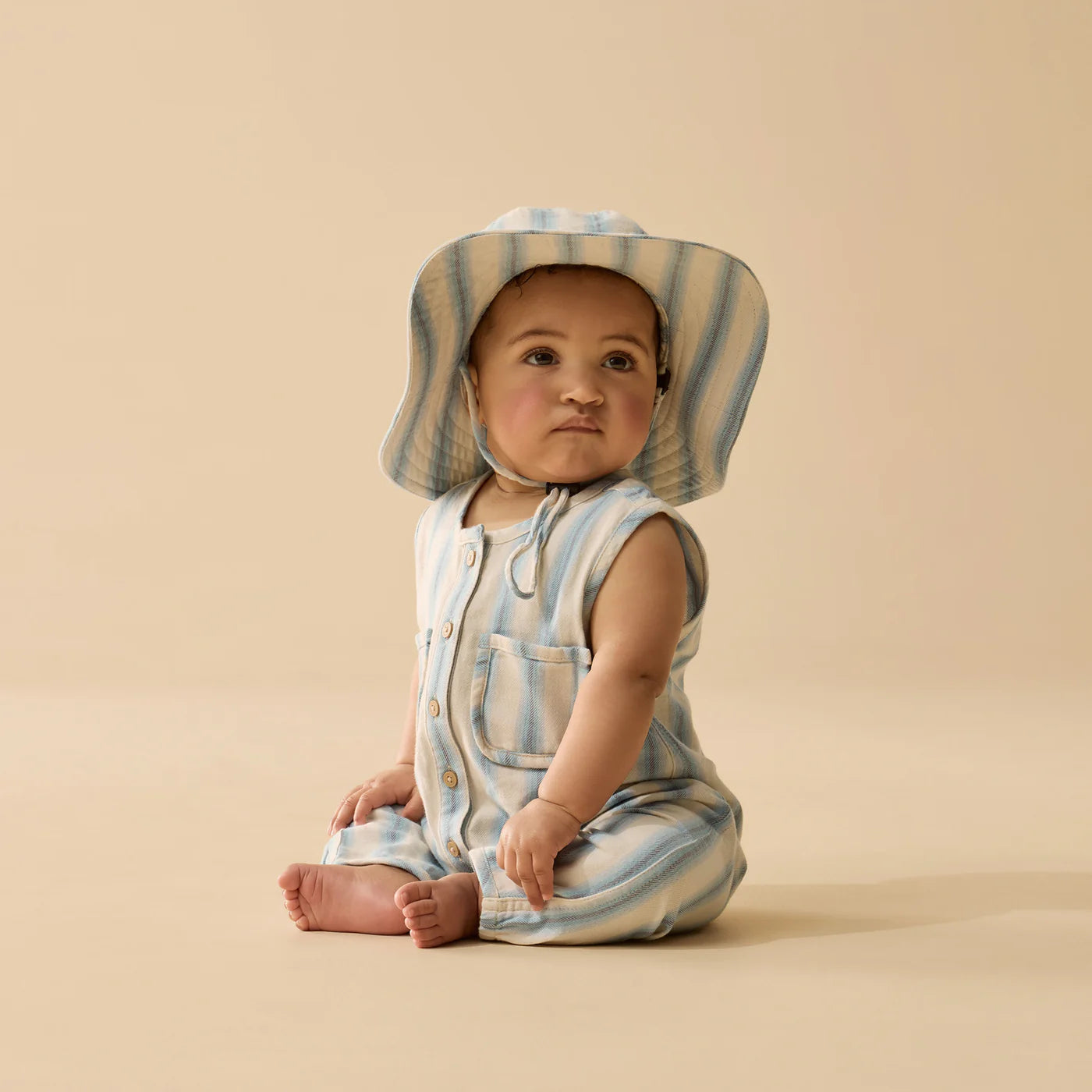 Behind The Trees - Striped baby romper with button details on a white background - Wilson + Frenchy - Stripe Organic Growsuit - Deep Blue