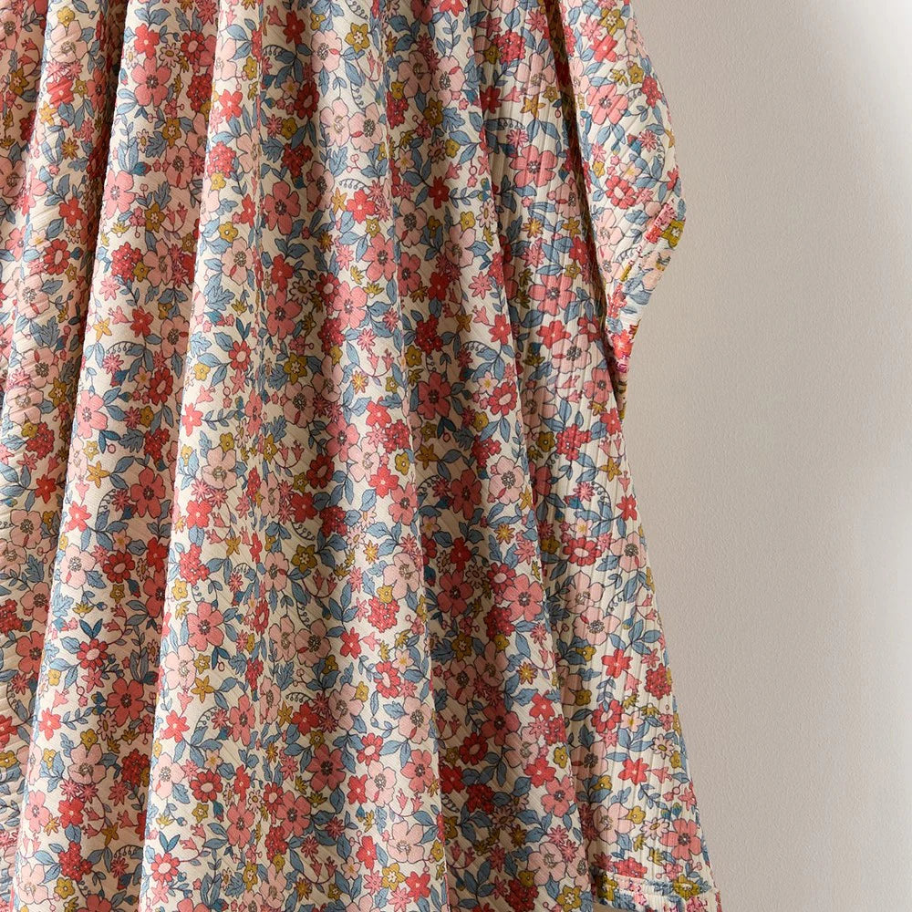 Behind The Trees - Rolled-up floral fabric with a visible brand label on a white background - Wilson + Frenchy - Organic Bunny Rug - Summer Bloom