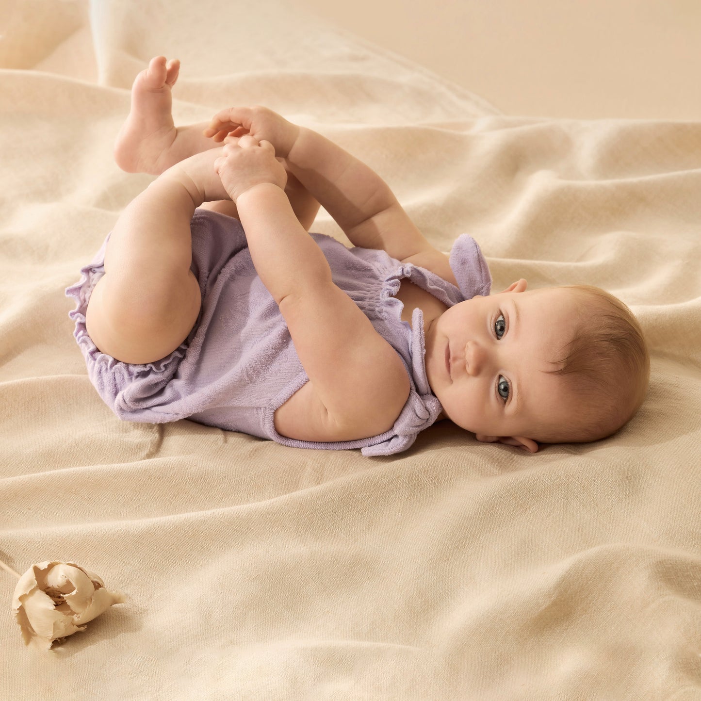 Behind The Trees - Purple baby romper with bear ears on a white background - Wilson + Frenchy - Organic Terry Tie Playsuit - Lavender Shells