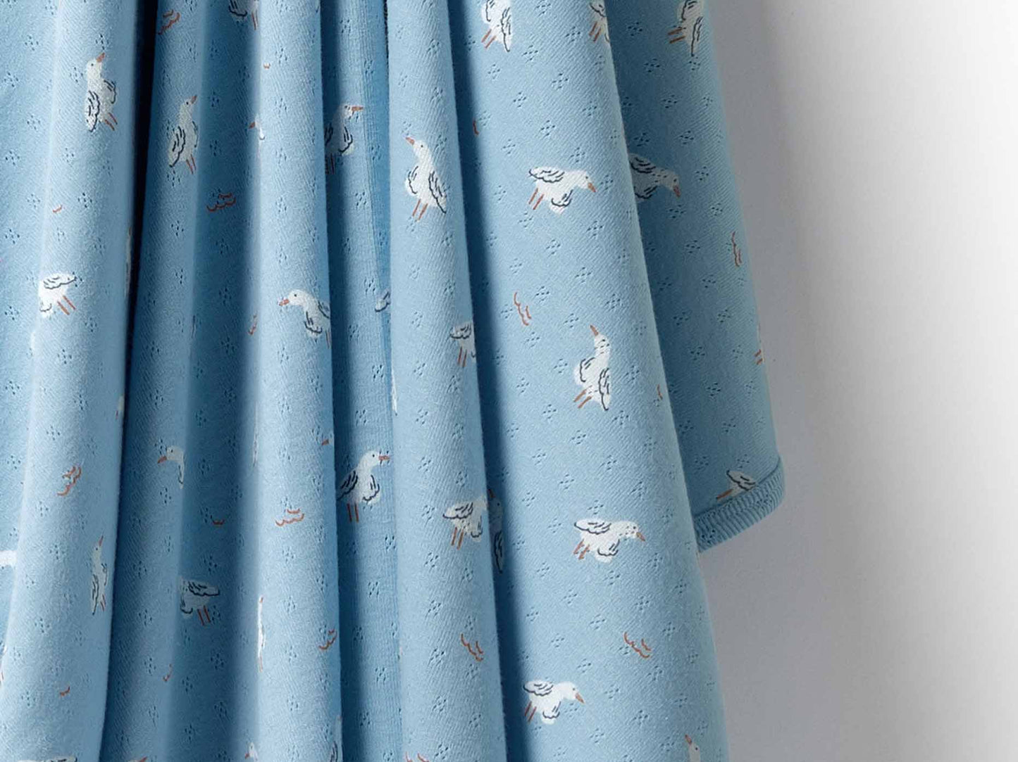 Behind The Trees - Rolled-up light blue blanket with a tag on a white background - Wilson + Frenchy - Organic Pointelle Bunny Rug - Sunny Seagulls