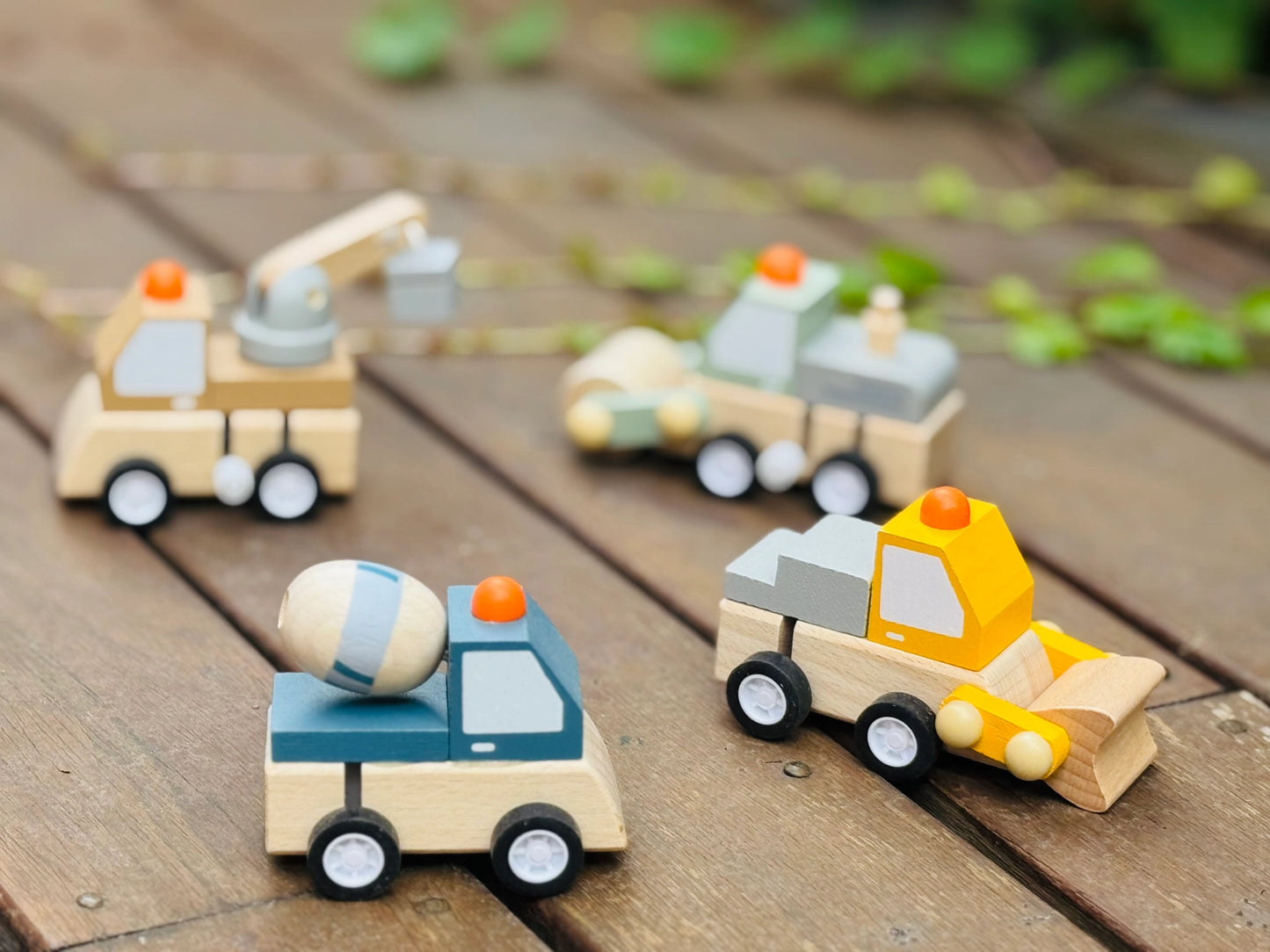 Behind The Trees - Set of four wooden toy construction vehicles on a white background - Toyslink - Wooden Wind-Up Construction Trucks