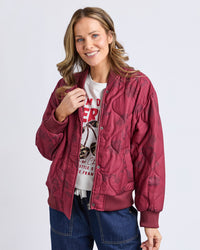 Behind The Trees - Woman wearing a red jacket over a graphic t-shirt on a white background - Elm - Bramble Jacket - Plum Bramble Print