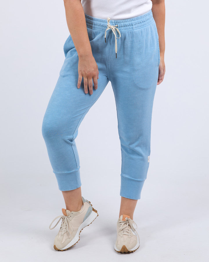 Behind The Trees - Elm - Brunch Pant - Dusk Blue - Elm Clothing Outlet - Elm Lifestyle Stores - Elm Lifestyle clothing - Elm Lifestyle Dresses - Elm Lifestyle Stockists - best casual 3/4 length pants - lightweight 3/4 length pants - cotton pants - Light blue jogger pants worn by a person on a white background