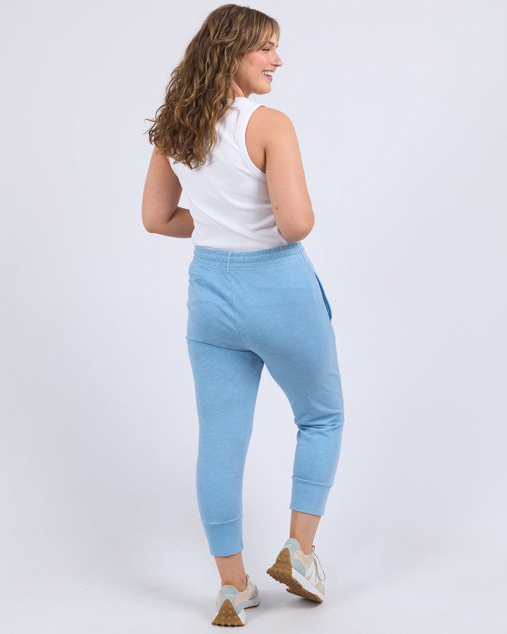 Behind The Trees - Elm - Brunch Pant - Dusk Blue - Elm Clothing Outlet - Elm Lifestyle Stores - Elm Lifestyle clothing - Elm Lifestyle Dresses - Elm Lifestyle Stockists - best casual 3/4 length pants - lightweight 3/4 length pants - cotton pants - Light blue jogger pants worn by a person on a white background