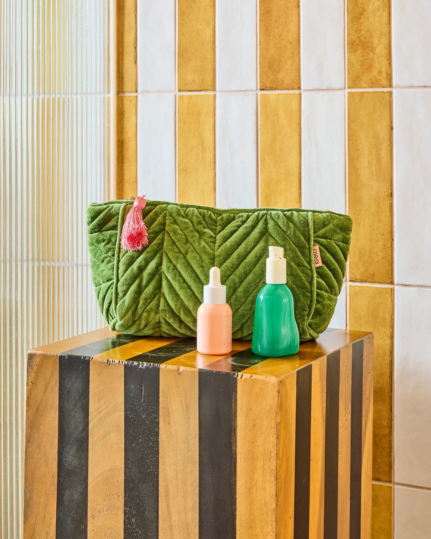 Behind The Trees - Green quilted clutch bag with a pink tassel on a white background - Kip & Co - Velvet Toiletry Bag - Moss
