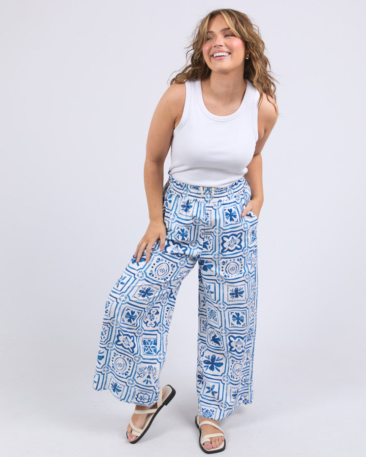 Behind The Trees - Blue and white patterned pants worn by a person on a white background - Elm - Dolce Tile Pant - Ocean Tile Pant