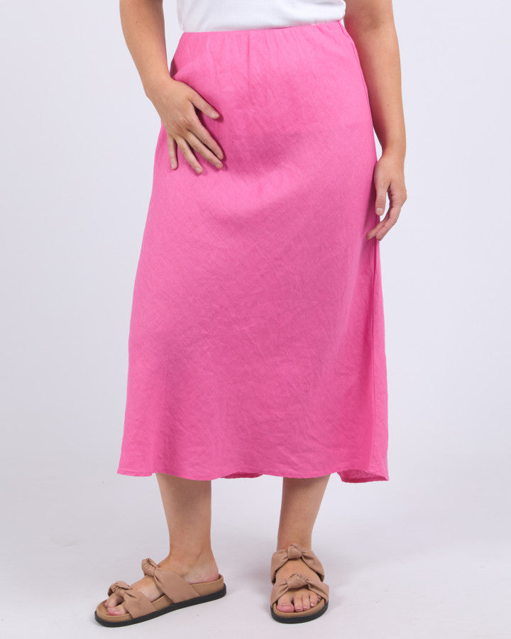 Behind The Trees - Elm - Eleni Skirt - Aurora Pink - Woman wearing a white top and pink skirt on a white background