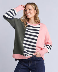 Behind The Trees - Woman wearing a colorful sweater with a striped pattern on a gray background - Elm - Freja Knit - Navy Block Stripe