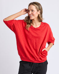 Behind The Trees - Woman wearing a red oversized shirt on a white background - Elm - Mazie Vee Sweat - Cranberry