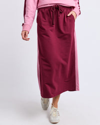 Behind The Trees - Person wearing a pink top and maroon skirt on a white background - Elm - Sloane Fleece Skirt - Plum/Quarts Pink Trim
